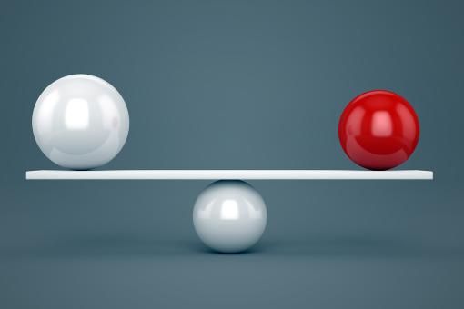 Balance concept - Red and white glossy balls on plank.